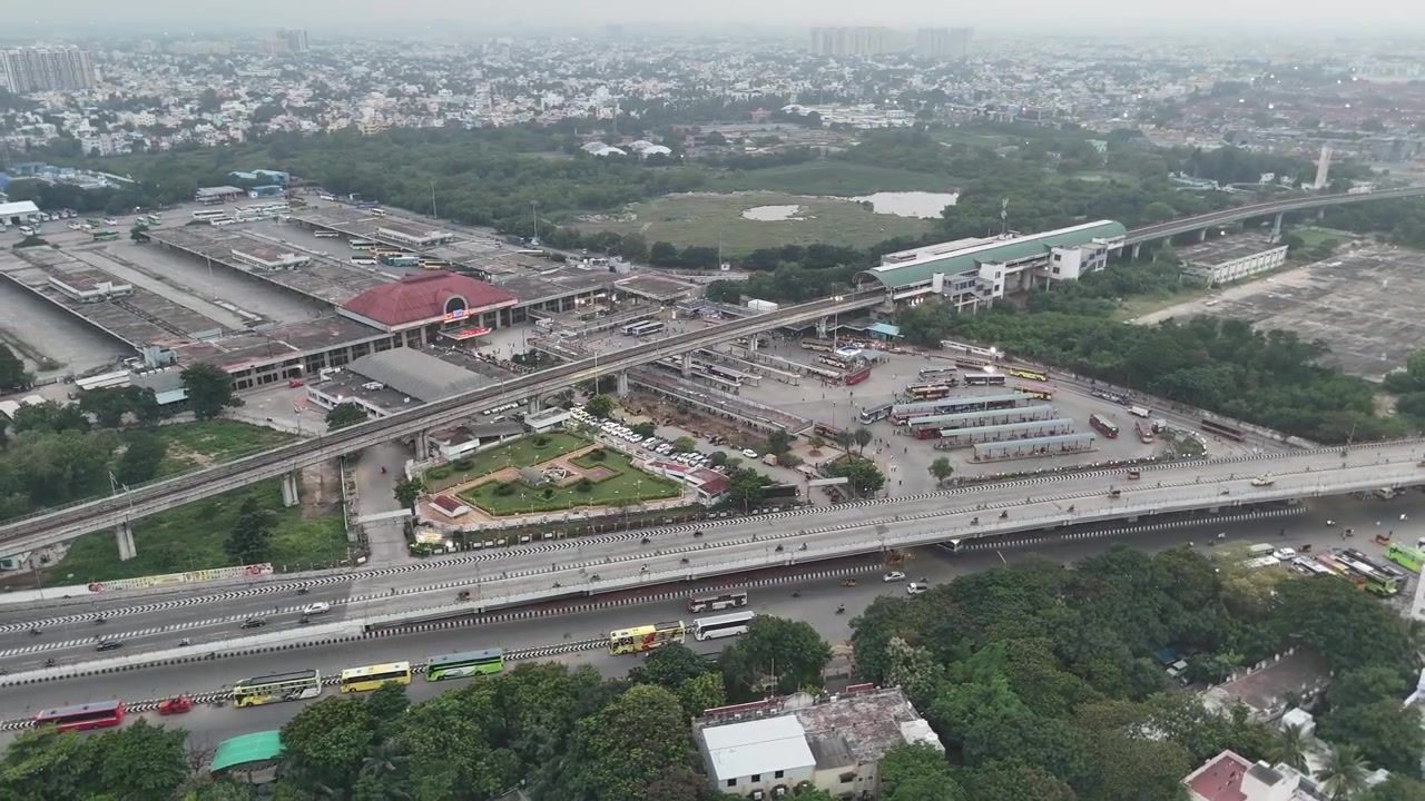 Librandosi sopra il vivace quartiere Koyembedu di Chennai, questo video aereo riprende il più grande terminal degli autobus della città e gli imponenti complessi residenziali che lo circondano.