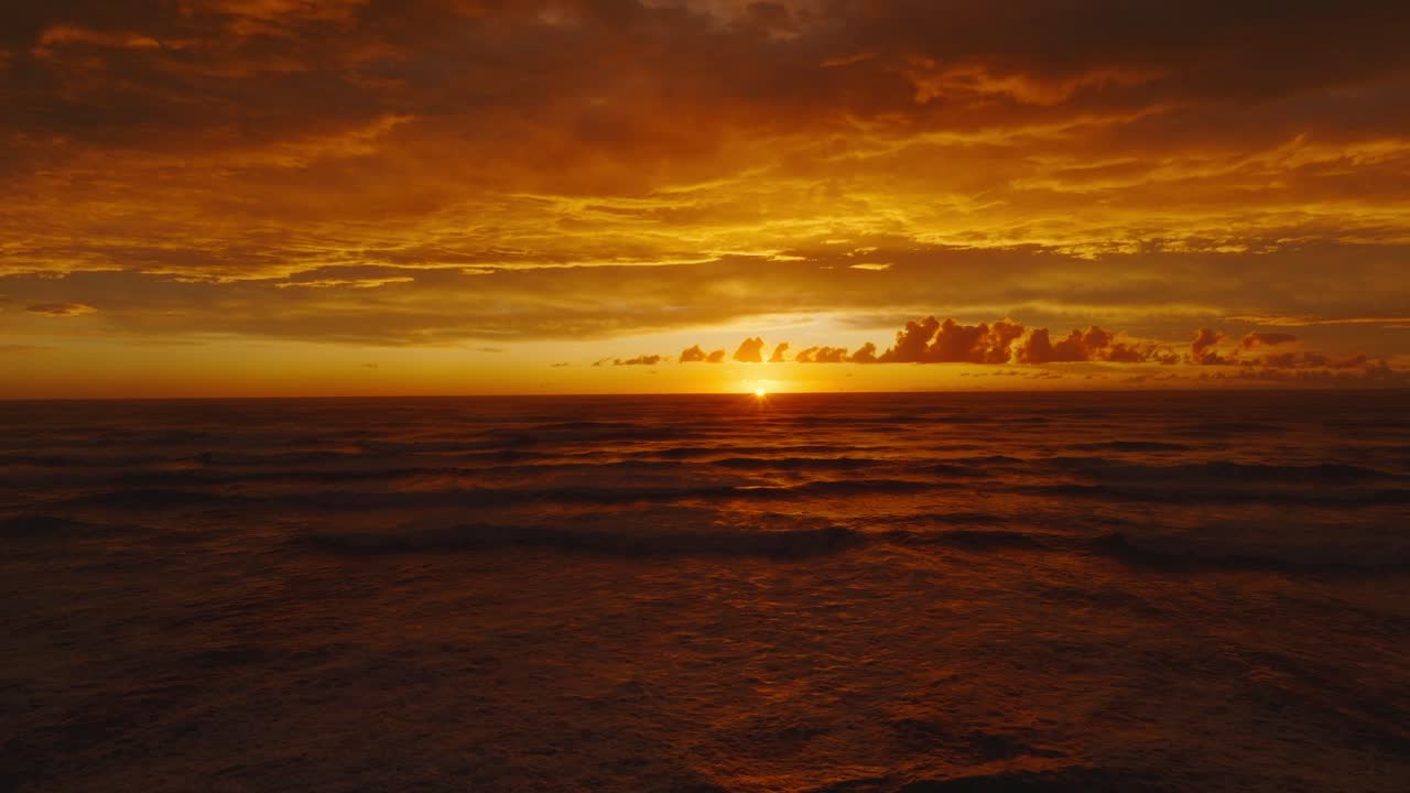Reverse aerial view of stunning golden sunset with dramatic cloudy sky and the Tasman Sea at Pancake Rocks on the wild West Coast of South Island in New Zealand Aotearoa