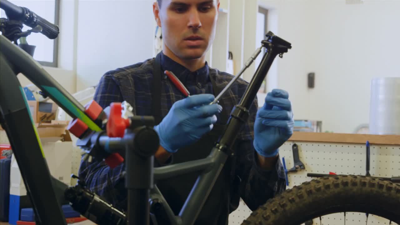 hombre reparando una bicicleta en el taller 4k