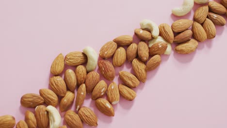 video of almonds and nuts on pink background