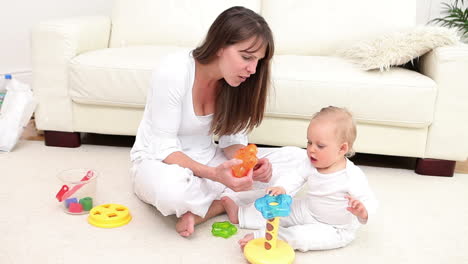 woman and baby playing with a toy