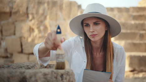 arqueólogo pintando una piedra histórica