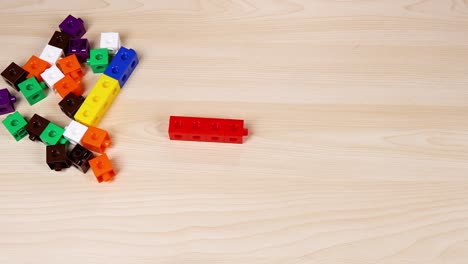 hands assembling colorful linking cubes on table