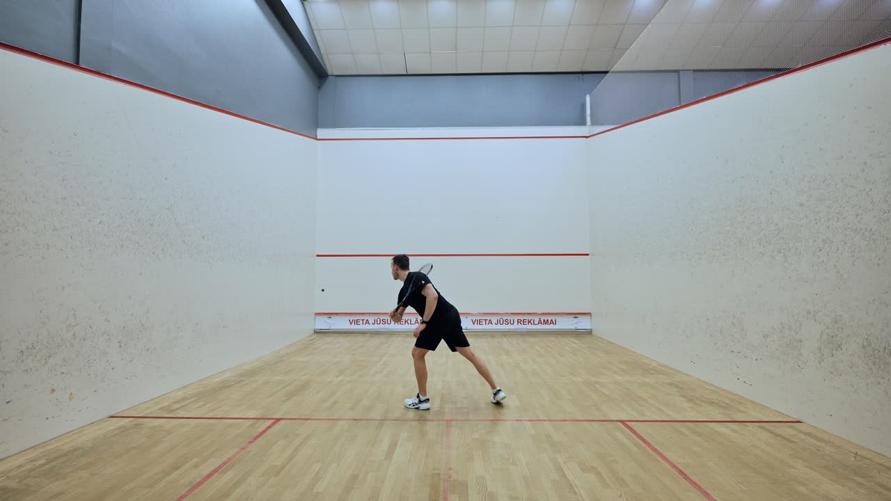 Dedicated squash player performing repetitive figure-eight drills on court - 4K