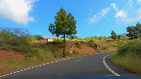 Paseo-Panorámico-Por-La-Montaña-En-Una-Carretera-Con-Curvas,-Punto-De-Vista-Del-Conductor,-Rodeado-De-Montañas-Altas-Y-Vegetación-Verde-Exuberante,-Lapso-De-Tiempo,-Parque-Nacional-Del-Teide,-Tenerife,-Islas-Canarias,-España,-Europa