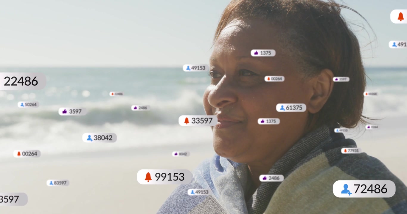 Alerts popping, wrapped woman on beach watching badges floating around showing marketing reach