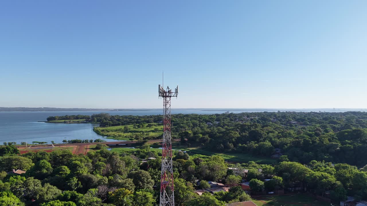 Aerial drone view of telecommunication tower surrounded by green forest and rural landscape, modern connectivity and technology