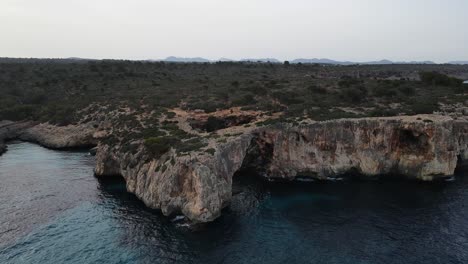 Vista-De-Drones-De-Acantilados-De-Coral-Huecos-En-La-Playa-De-Cala-Varques,-Mallorca,-España