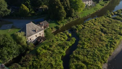 Aerial view of a watermill by a river surrounded by nature