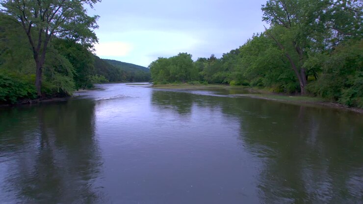 Drone aerial close up float close to the water opening to a clearing of the Susquehanna river in Pennsylvania