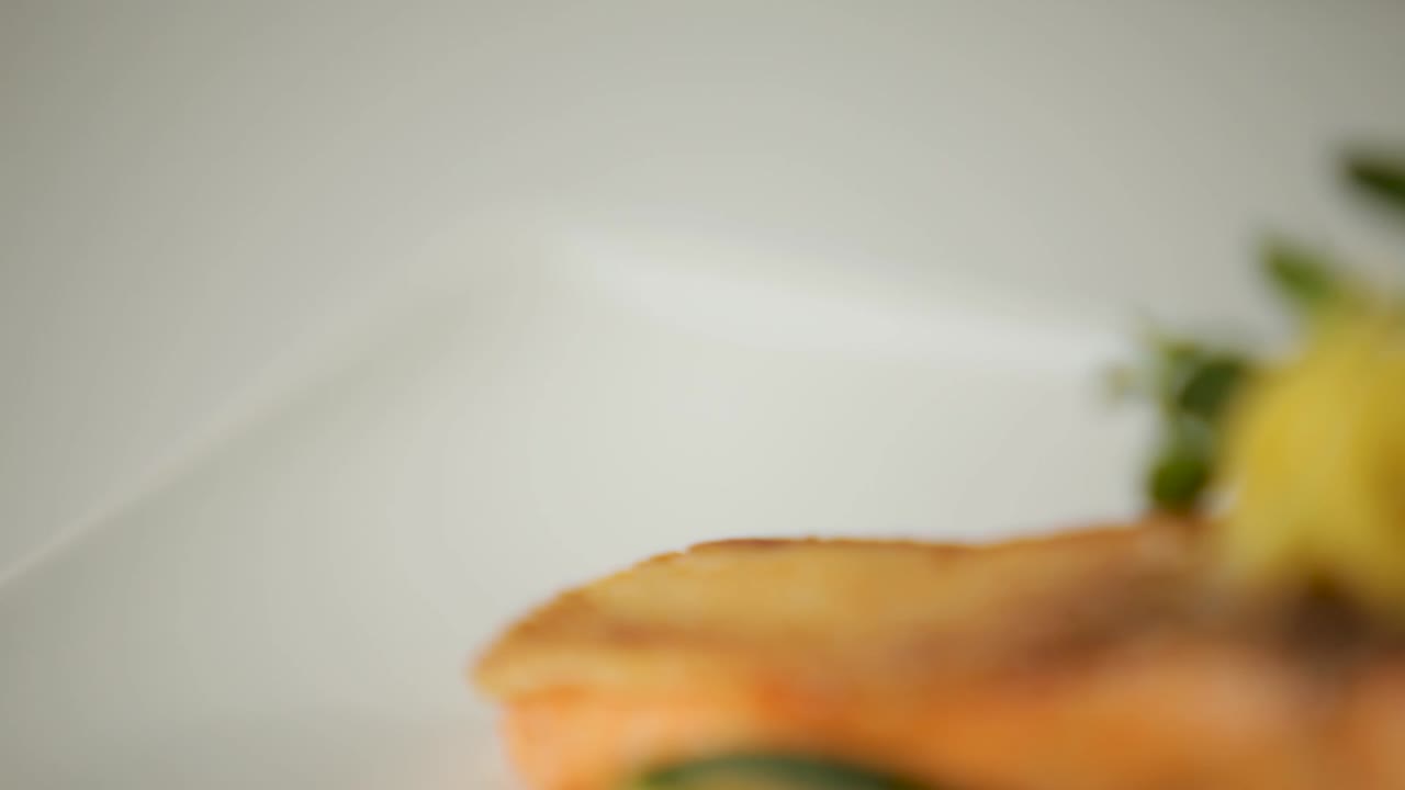 primer plano de un filete de salmón hermosamente cocido adornado con un toque de limón y verduras frescas, en un lecho de verduras de colores