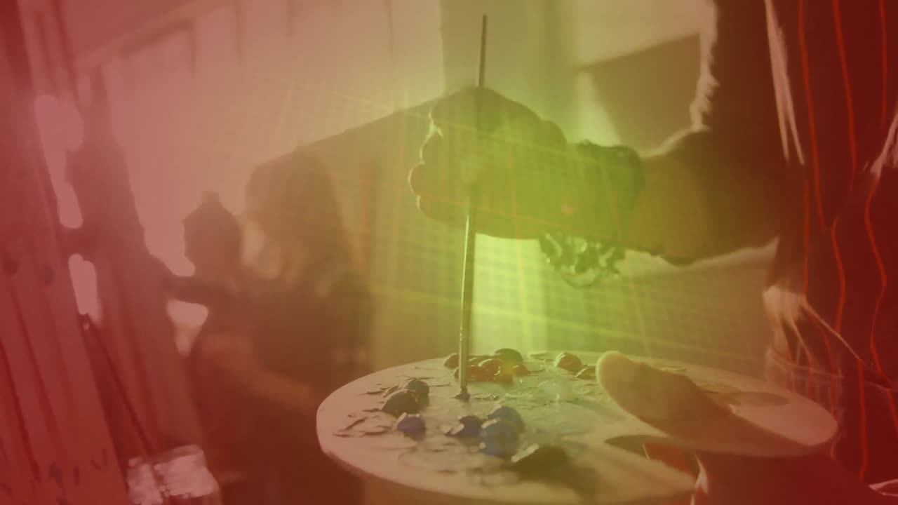 puntos de luz contra la sección media de una persona pintando en el estudio