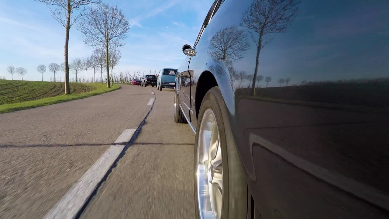 봄날 들판을 가로질러 도로를 달리는 차의 바깥쪽 샷