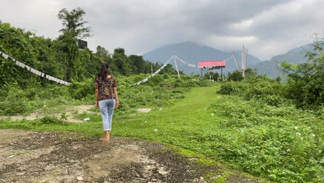 Vista-Trasera-De-Una-Joven-India-Feliz-Caminando-Por-Caminos-De-Montaña-Y-Visitando-La-Tumba-Tradicional-De-Los-Budistas-En-La-Cima-De-La-Colina