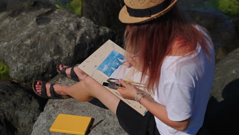 woman painting watercolor at the beach