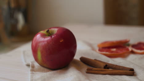 Apfelfrüchte-Und-Zimtstangen-Auf-Dem-Küchentisch.-Apfel--Und-Grapefruitscheiben