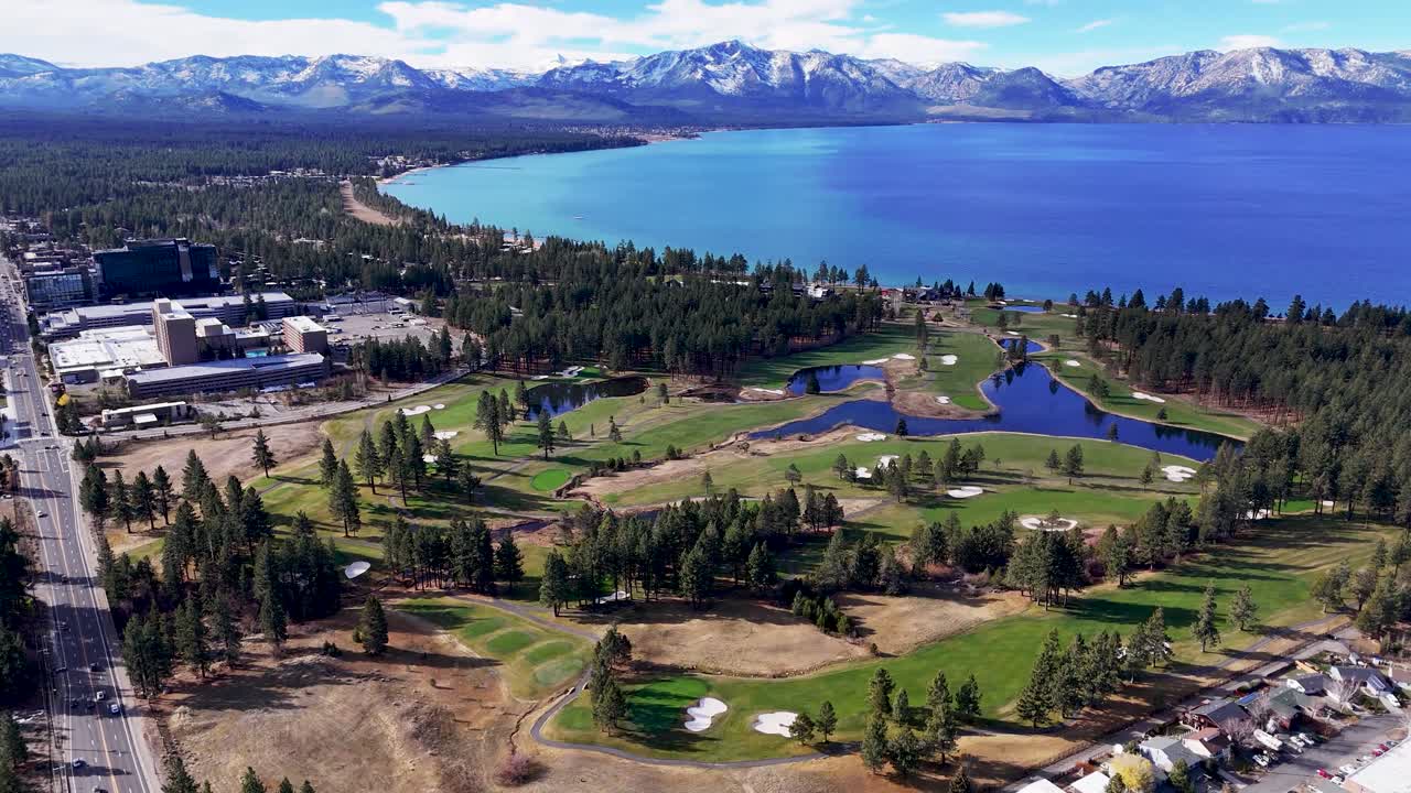 Aerial view of South Lake Tahoe golf course and town with lake and mountain background
