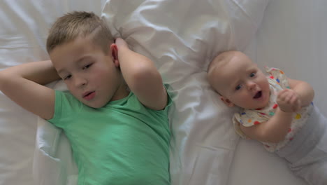 Brother-with-junior-sister-on-bed-at-home