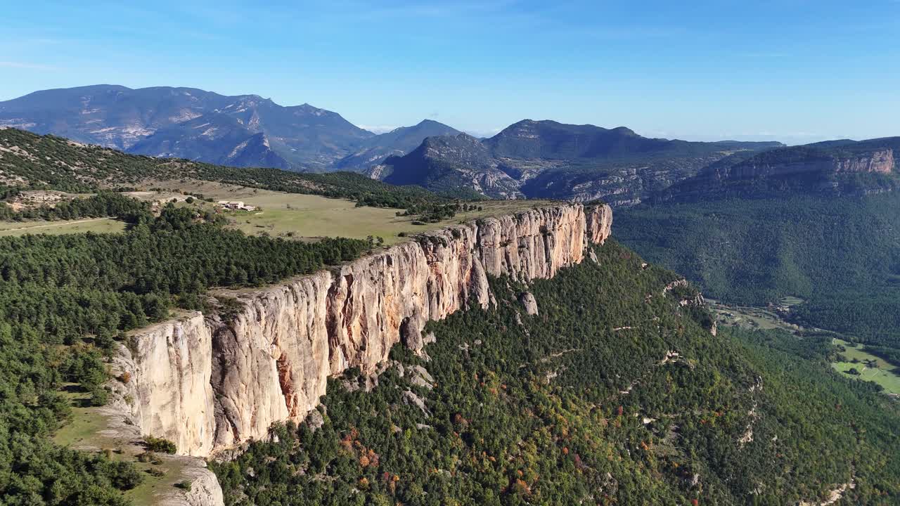 Aerial View of a Dramatic Cliff Face in a Mountainous Valley