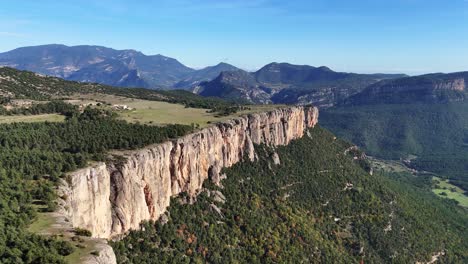 aerial view of a dramatic cliff face in a mountainous valley