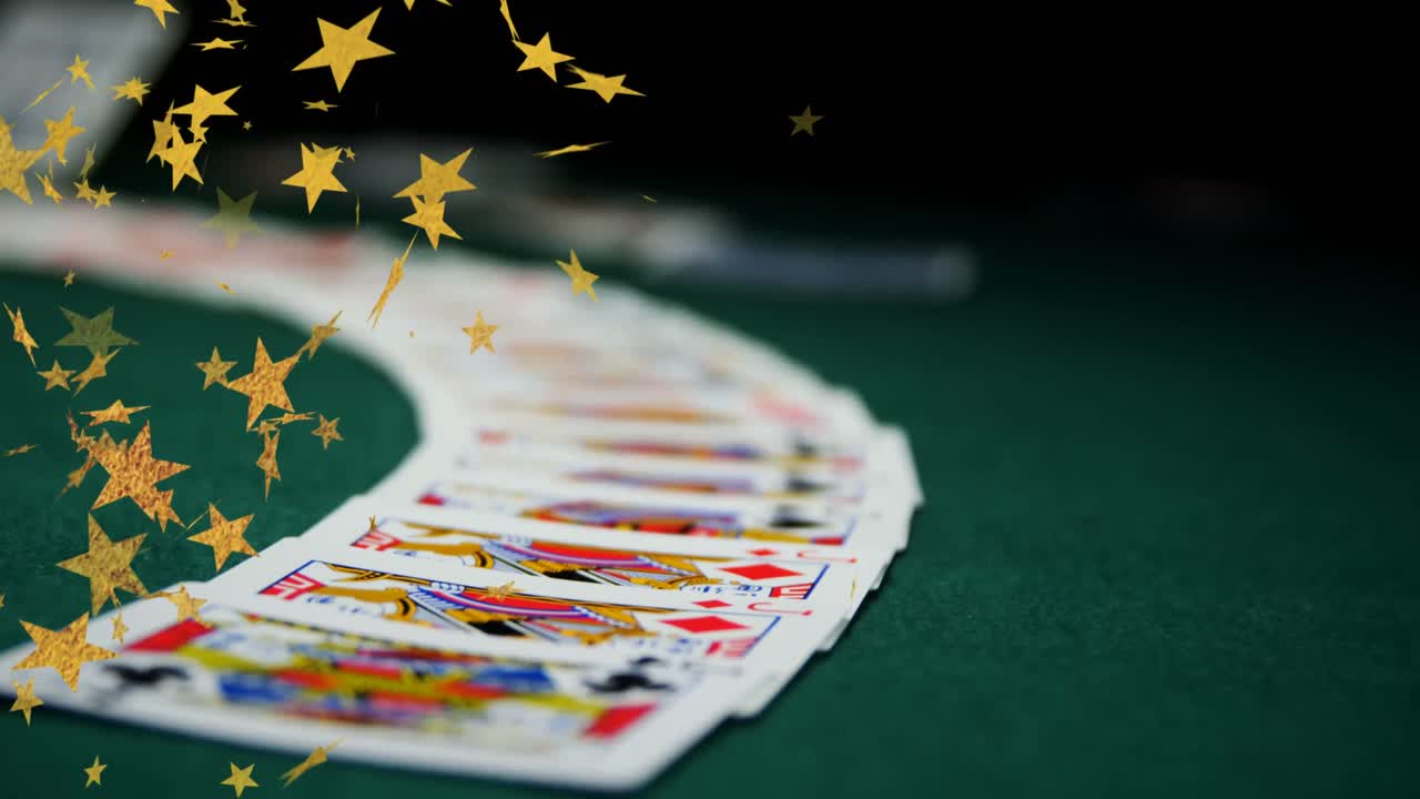 video compuesto de múltiples iconos de estrellas doradas que caen contra las cartas de juego en la superficie verde