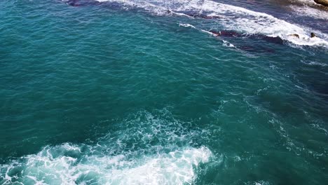 foamy waves hitting rocky coast of crete, aerial view