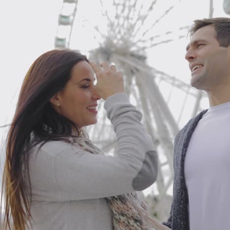 Young-couple-standing-in-front-of-a-ferris-wheel