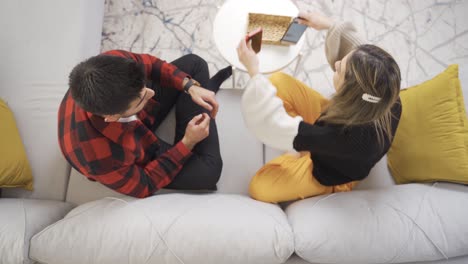 A-young-couple-sits-embedded-in-smartphones-and-ignores-each-other.