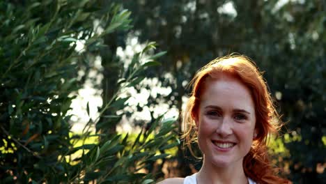 Smiling-woman-standing-in-olive-farm-on-a-sunny-day