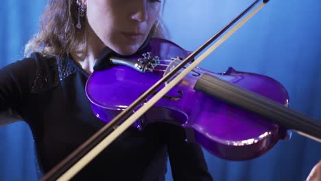 la violinista toca el violín en la escuela de música, el músico toca el violín en la ópera.