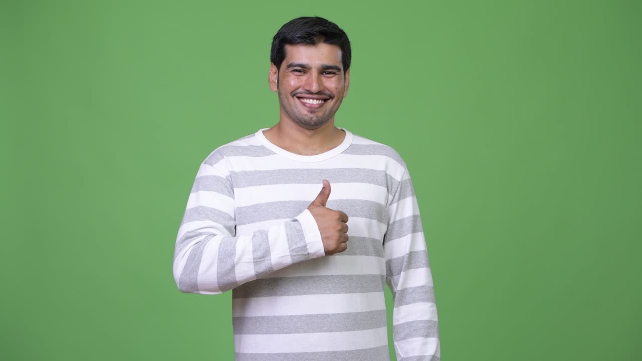 Young handsome Persian man giving thumbs up