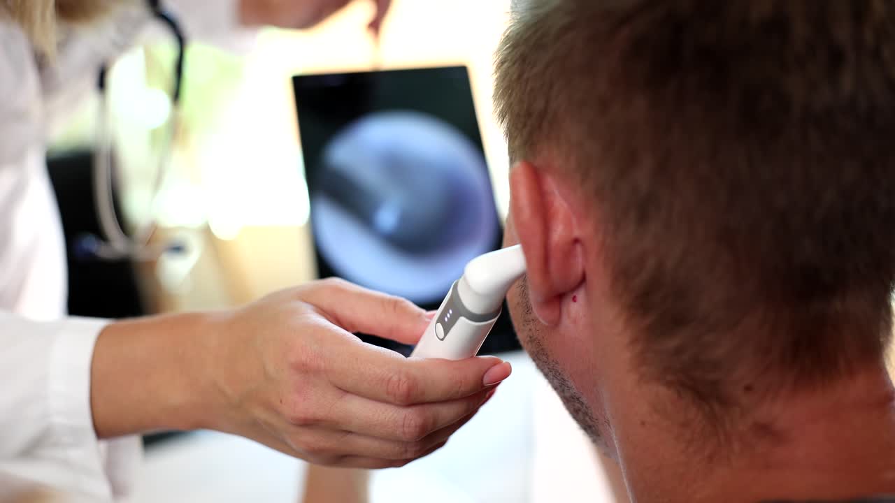 Otorinolaringoiatra esamina l'orecchio del paziente con un otoscopio digitale