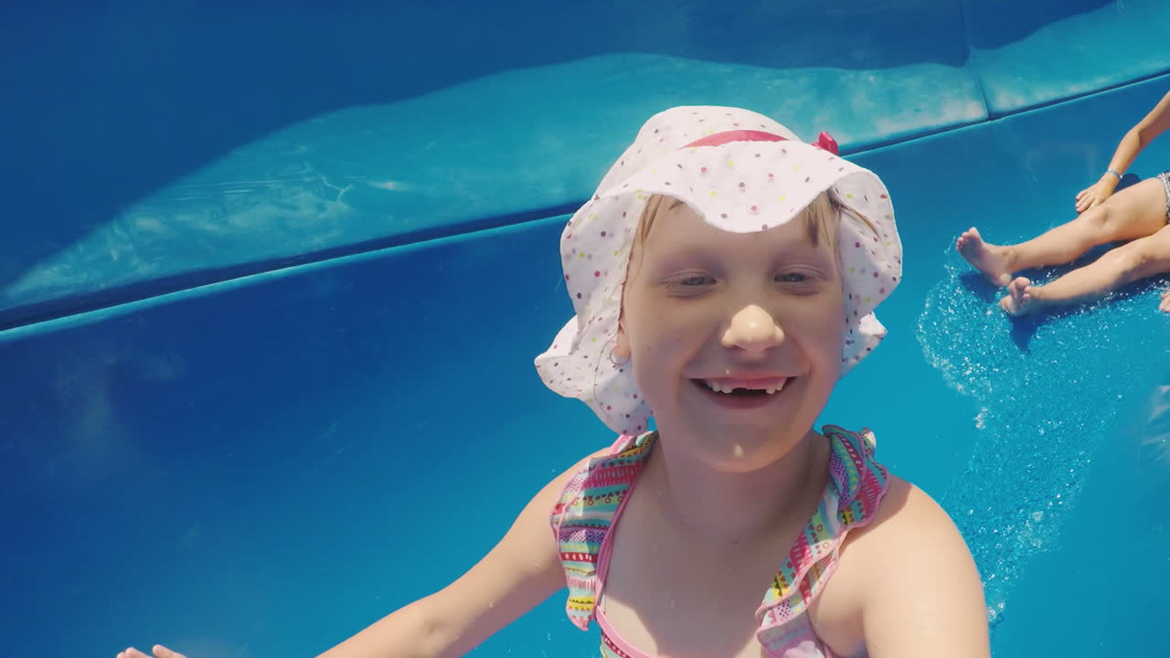 mamá e hija se divierten por el tobogán de agua riendo familia feliz de vacaciones