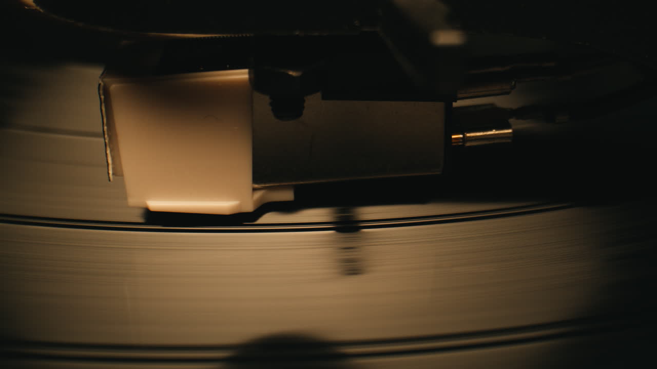 Aghi di un giradischi che seguono i solchi di un vinile in rotazione