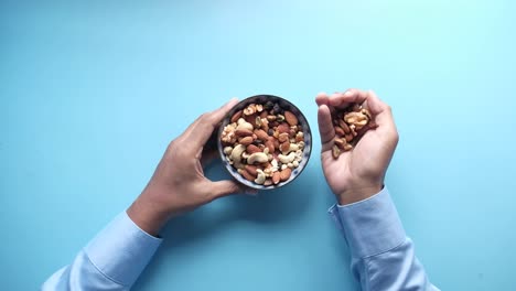 person eating mixed nuts from a bowl