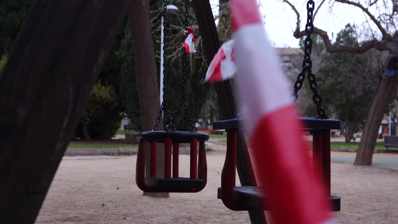 그네가 있는 아이들을 위한 놀이터는 놀이 금지를 알리는 테이프로 닫혀 있습니다 - 코로나바이러스