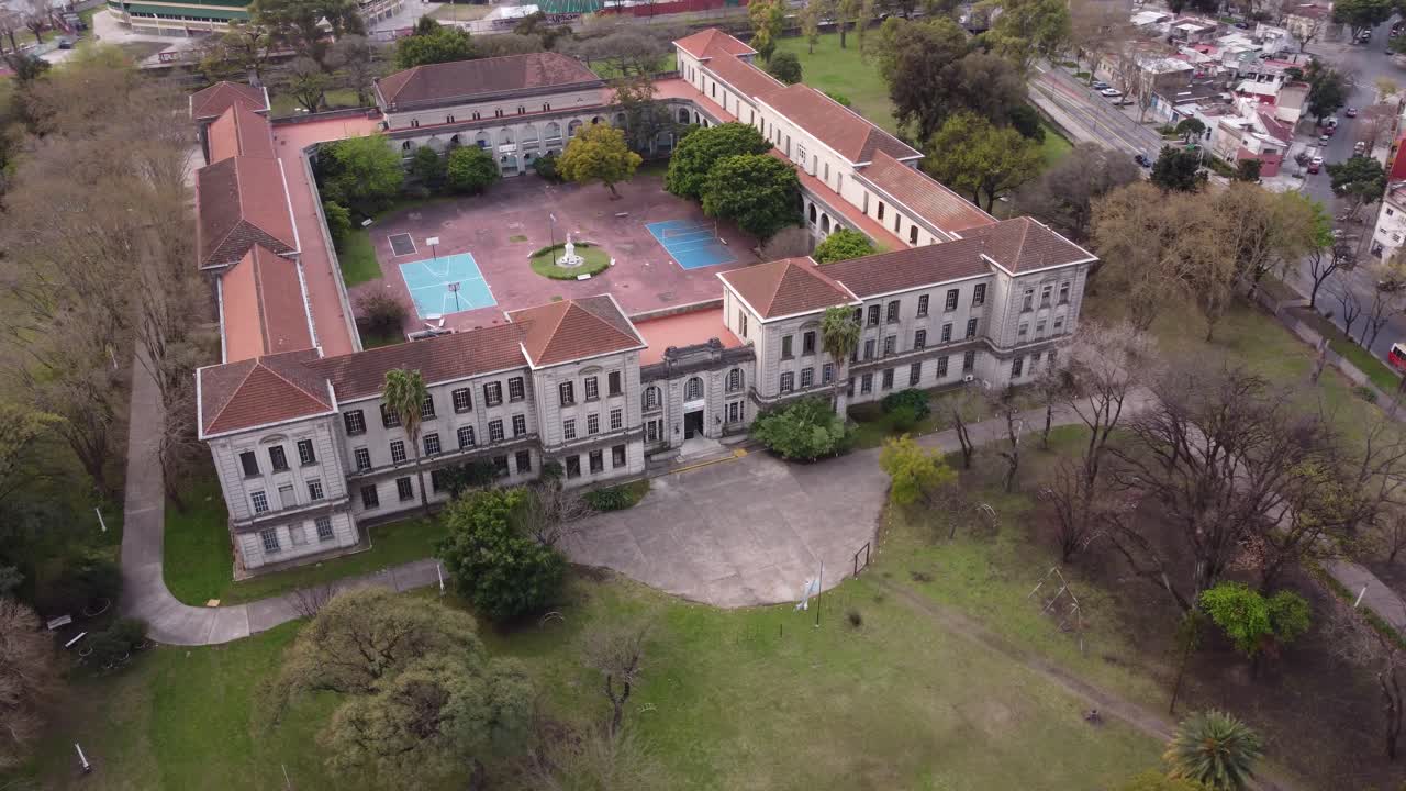 vista aérea que muestra la histórica vieja escuela clásica en buenos aires rodeada por un bosque verde