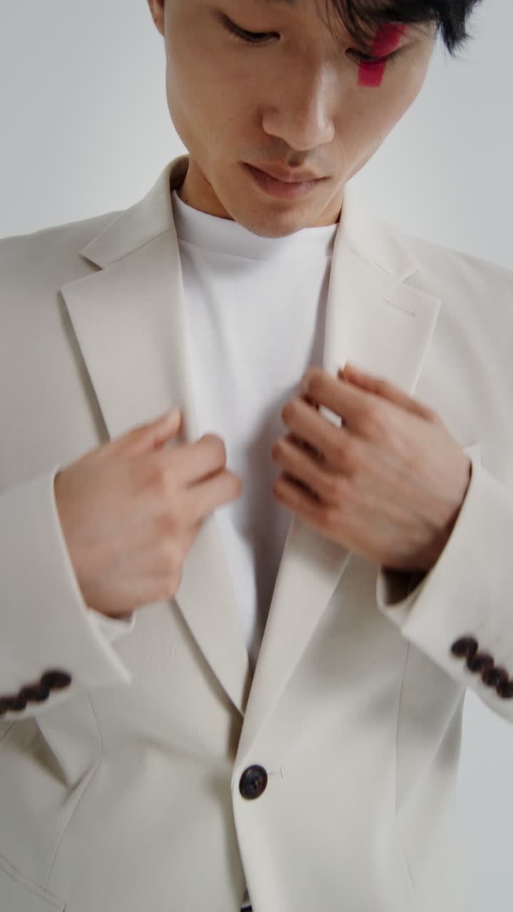 Close-up of a person wearing a white suit and t-shirt