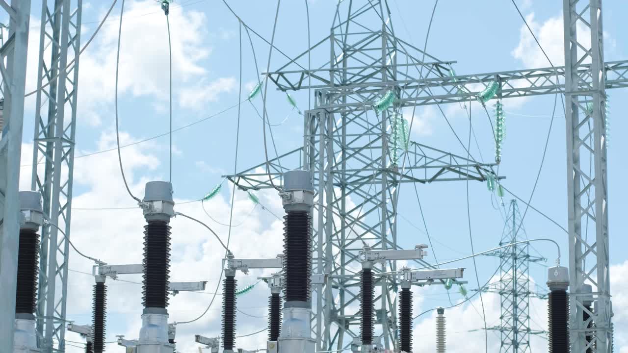 은 파란 하늘 아래 현대 변전소의 스위치 야드에서 지원 및 케이블 버스 파이프에 과거 운동 유리 단열기