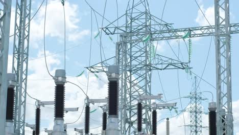 motion past glass insulators on supports and cable bus pipes in switchyard of contemporary substation under clear blue sky