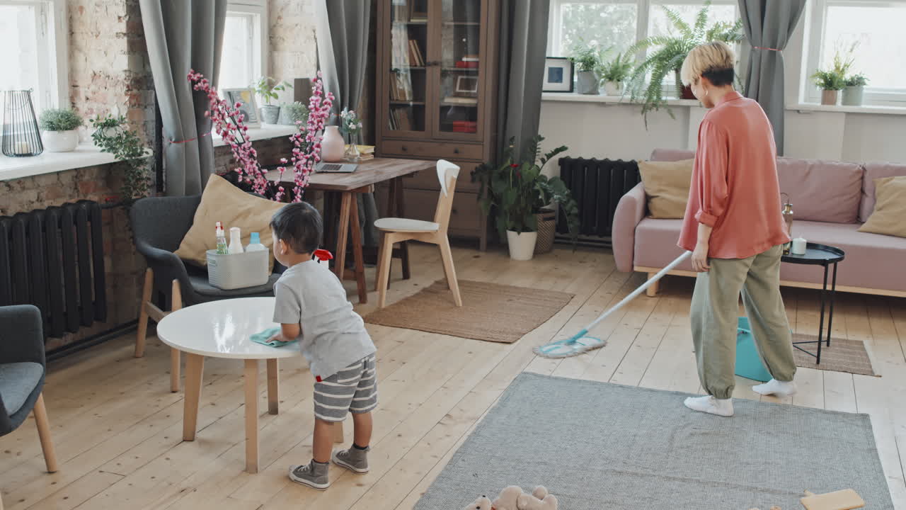 Aziatische vrouw die samen met haar zoon aan het schoonmaken is