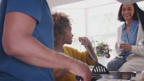 Padres-Afroamericanos-Y-Su-Hija-Preadolescente-Preparando-Comida-Juntos-En-La-Cocina,-De-Cerca