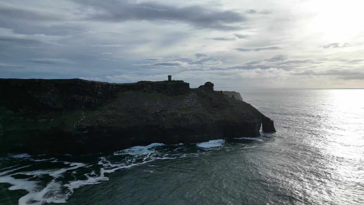 Aerial view of Cliffs of Moher, ocean waves and Tower at Hag's Head in Ireland