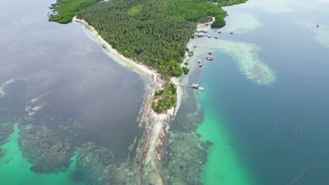 Panoramic-aerial-overview-of-Timbayan-rock-formation,-reef,-sandy-coastline,-palm-tree-forest