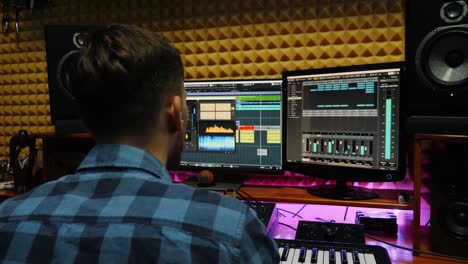 sound engineer creating song in professional recording studio. musician working at home studio with monitors and equalizer mixing gear on screen. music composing process