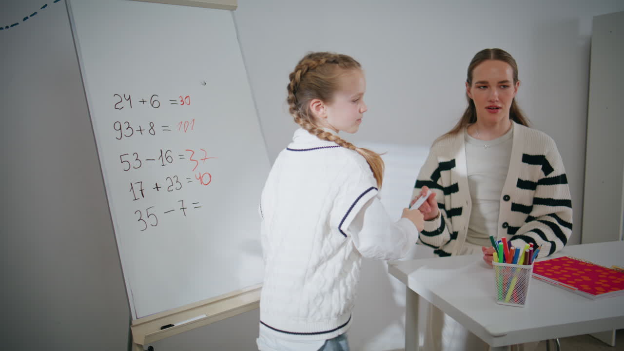 Cute schoolgirl writing whiteboard in classroom closeup. Girl having lesson