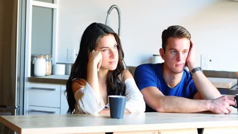 Pareja-Pensativa-Sentada-En-La-Cocina