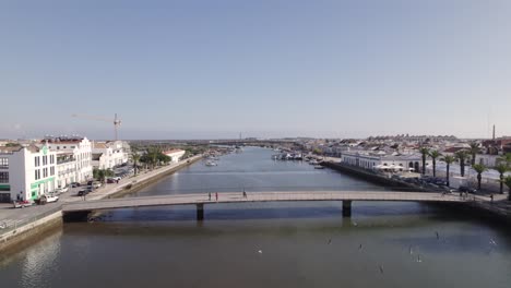 aerial flyover gilão river with bridge in tavira town during sunny day in portugal