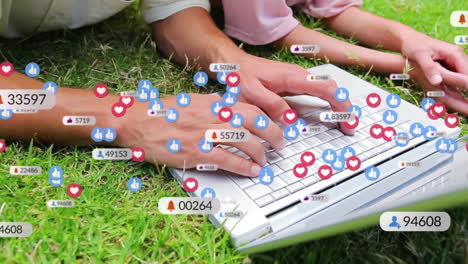 animación de iconos de redes sociales sobre la sección media de madre e hija usando portátil en el jardín