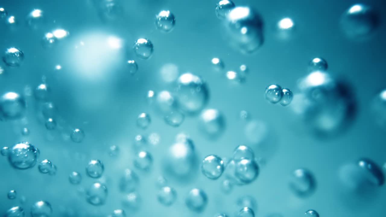 파란 물에 많은 물 거품이 가 ⁇ 게, 느린 움직임의 거품과 함께 추상적인 물 파동.